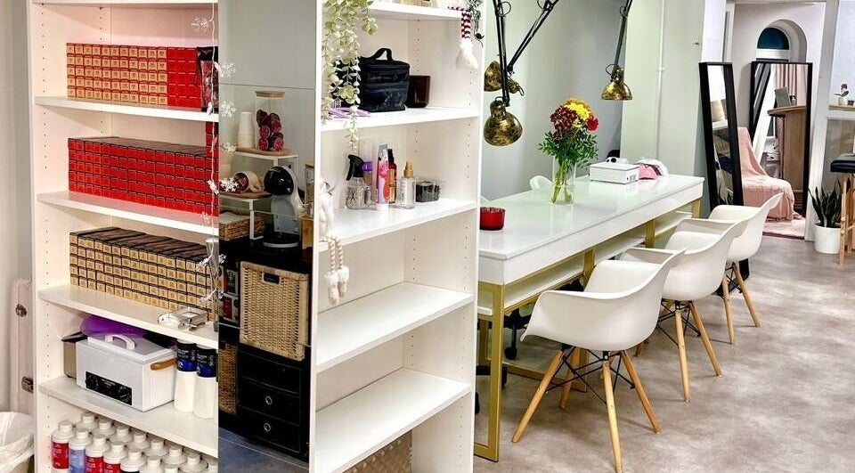 Interior moderno do Studio Zaina, Dublin, County Dublin, IE, com cadeiras brancas e prateleiras organizadas.