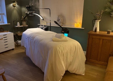 Relaxing treatment room at The Pampered Cow in Hixon, England, GB with massage table and ambient lighting.