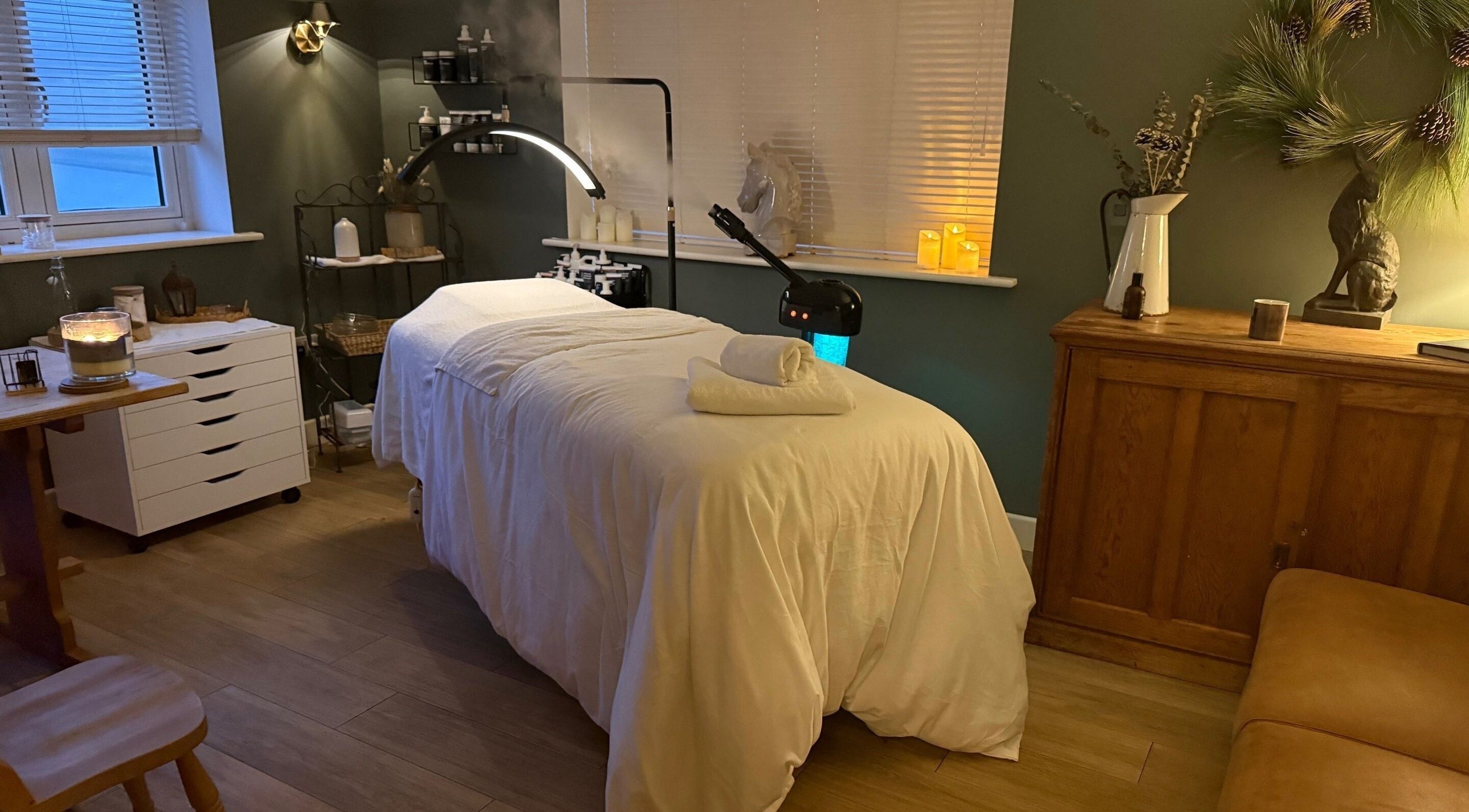 Relaxing treatment room at The Pampered Cow in Hixon, England, GB with massage table and ambient lighting.