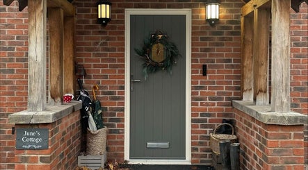 Charming entrance of The Pampered Cow in Hixon, England, GB displaying a decorated door and rustic decor.