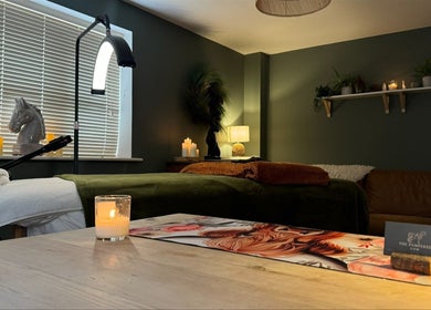 Relaxing spa room at The Pampered Cow, Hixon, England elegantly decorated with candles and plants.