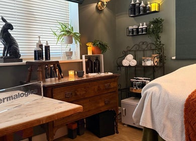 Cozy treatment room at The Pampered Cow, Hixon, England, GB with earthy decor and beauty products.