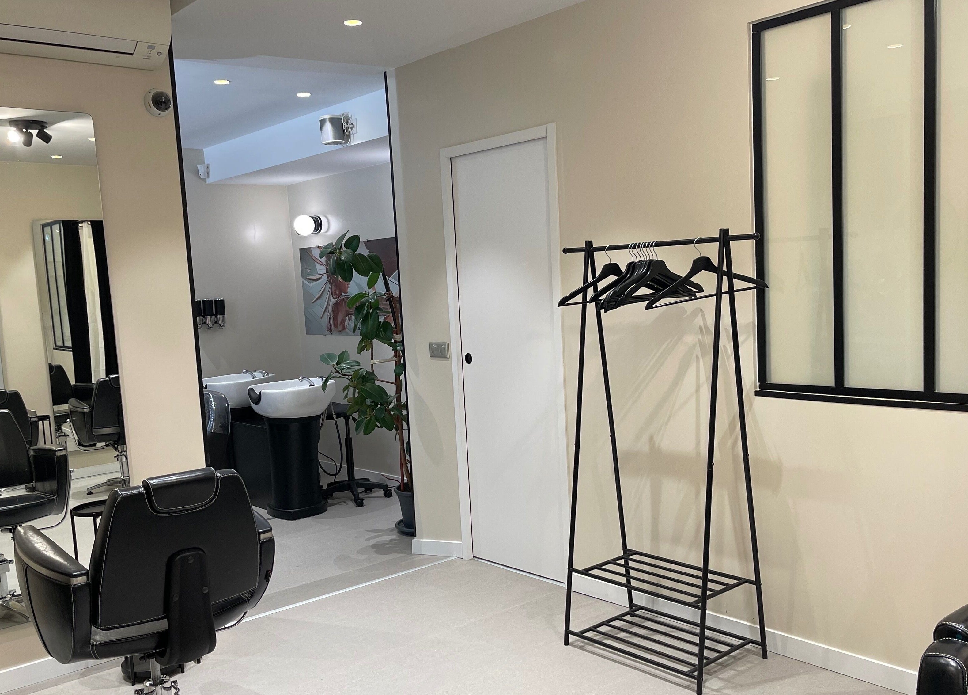 Intérieur élégant de Colorful Black à Paris, Île-de-France, FR. Miroirs, fauteuils et porte-manteau visibles.