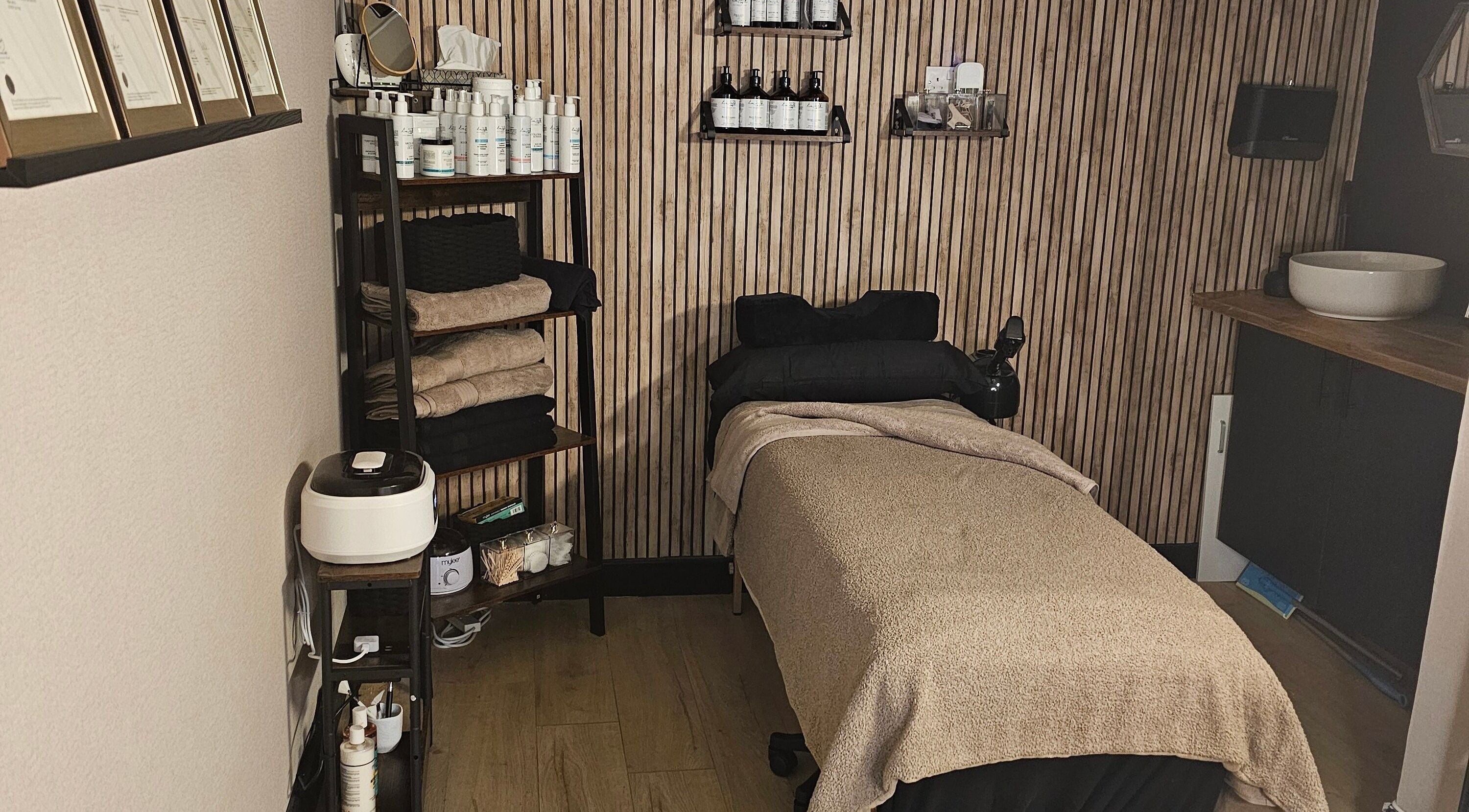 Cozy treatment room at O'U BEAUT - E in Halifax, England, GB with a massage table and skincare products.
