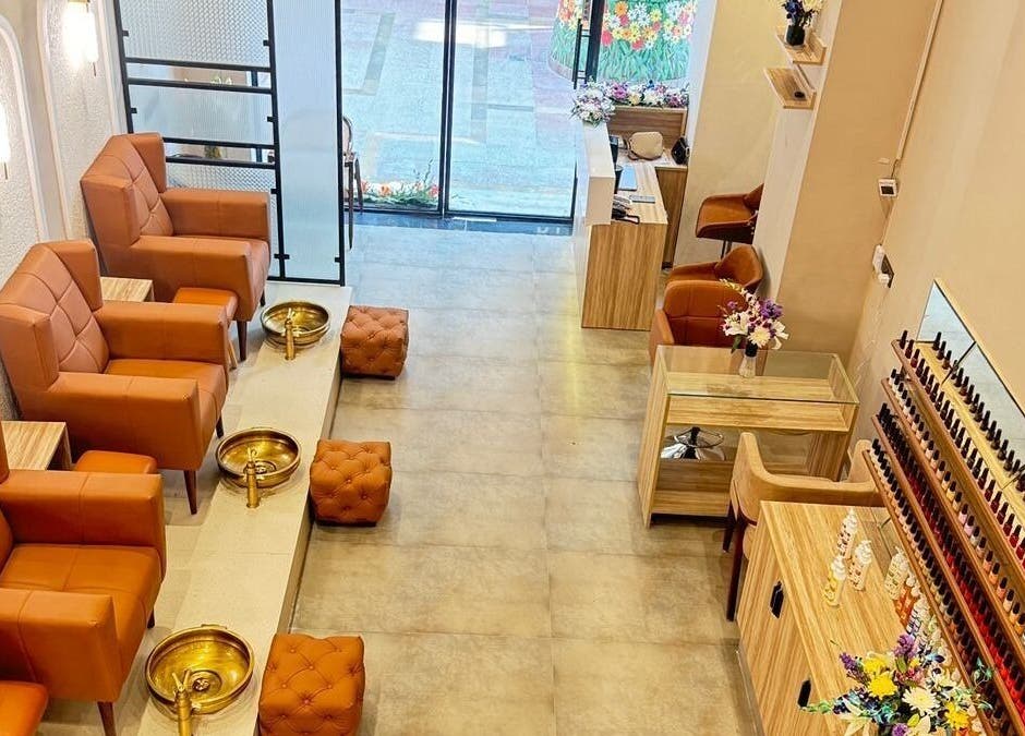 Elegant interior of The Mani Pedi Spa, AIPL Joy Street, Gurugram, Haryana, IN with plush chairs and nail polish display.