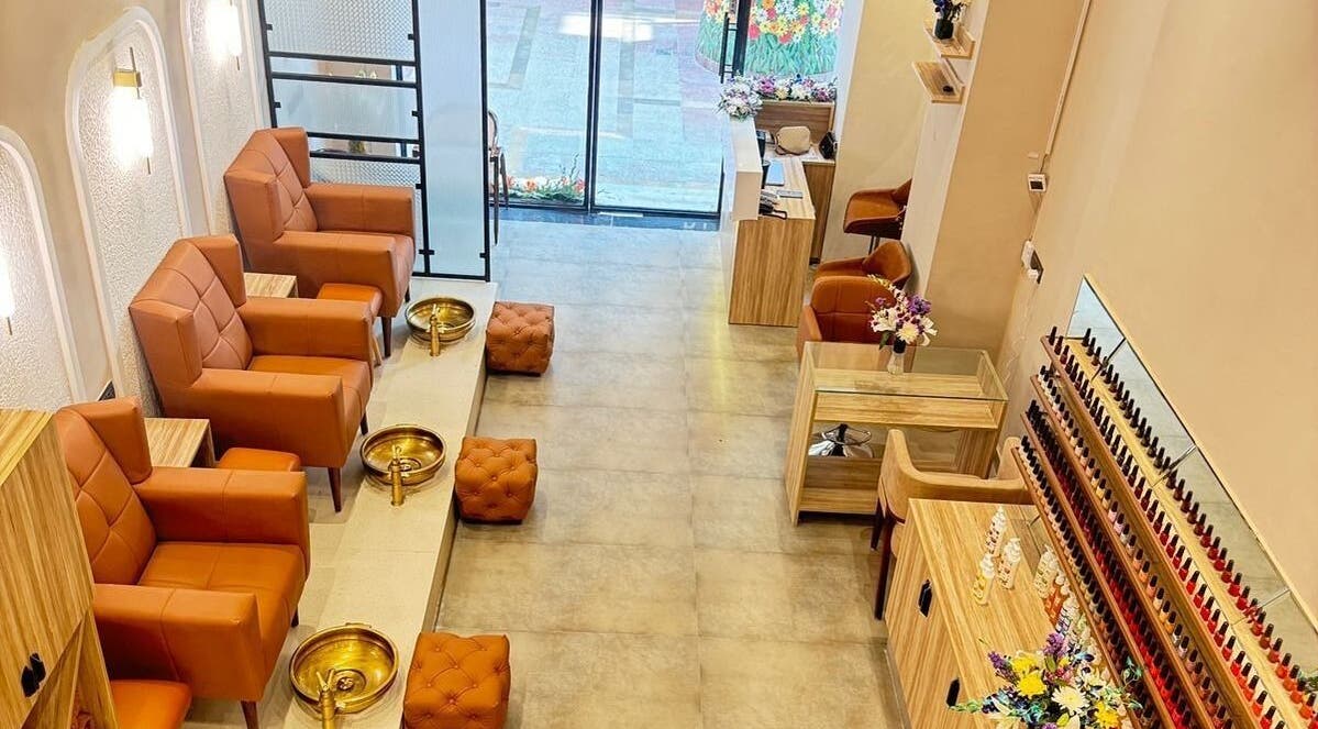 Elegant interior of The Mani Pedi Spa, AIPL Joy Street, Gurugram, Haryana, IN with plush chairs and nail polish display.