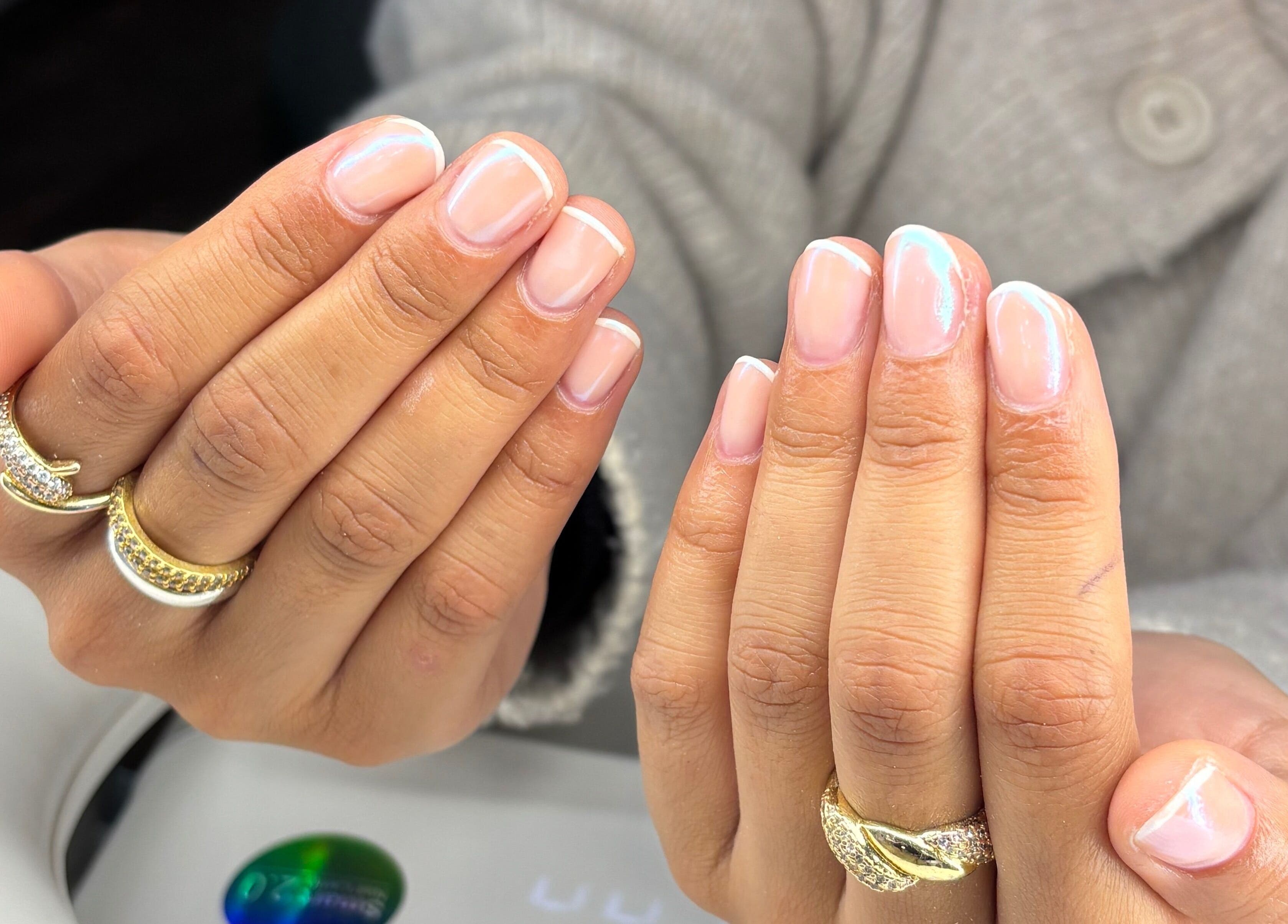 Beautiful French manicure at Blush Dundee, Dundee, Scotland, GB showcasing elegant nail art and rings.