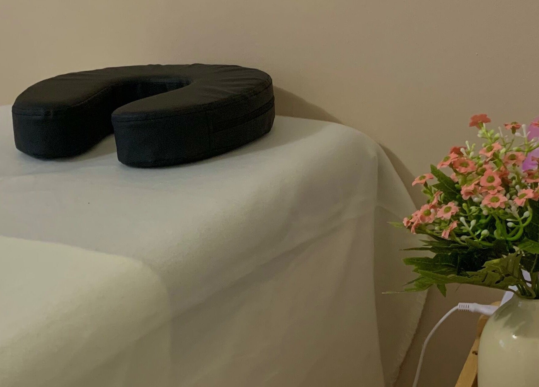 Coin détente chez Melslli Beauty Salon à Pia, Occitanie avec table de massage et décoration florale.