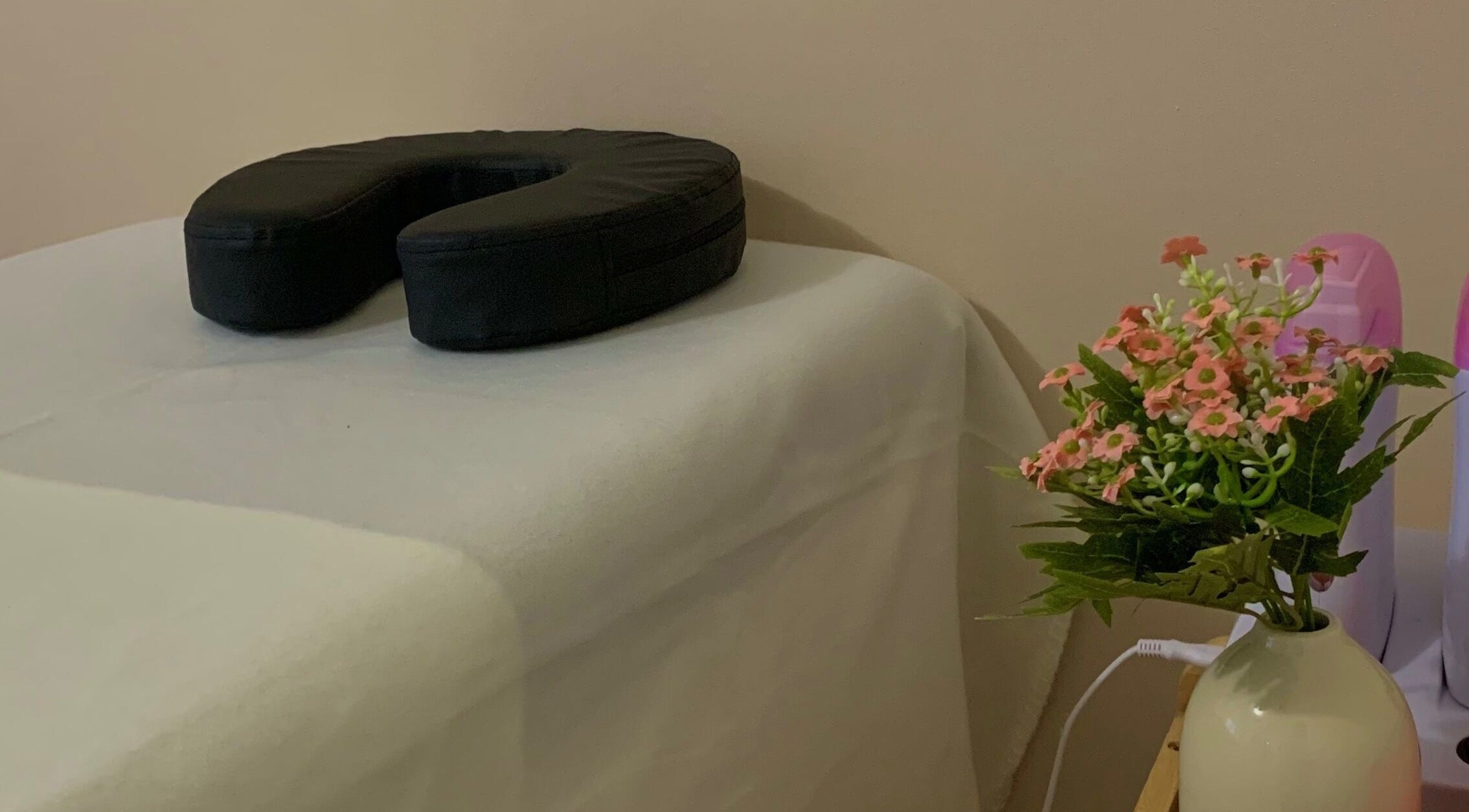 Coin détente chez Melslli Beauty Salon à Pia, Occitanie avec table de massage et décoration florale.