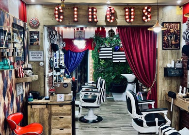 Interior retro de Circus Barber San Bernardo en Madrid, Comunidad De Madrid, ES con sillas vintage y decorado colorido.