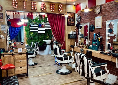 Interior de Circus Barber San Bernardo en Madrid, Comunidad De Madrid, ES, con sillas de barbero y decoración vintage.
