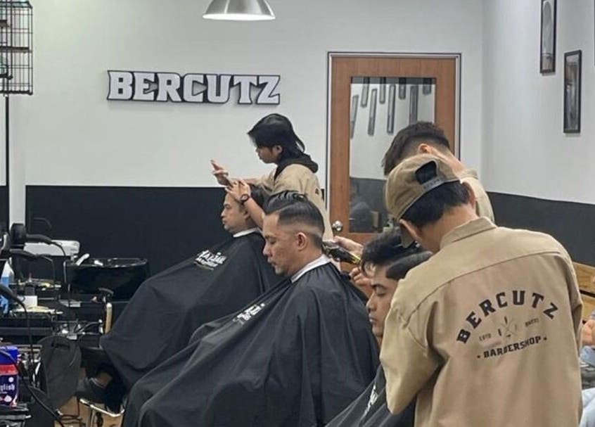 Stylish interior with customers getting haircuts at Bercutz Barbershop, Kuala Lumpur, Wilayah Persekutuan Kuala Lumpur, MY.