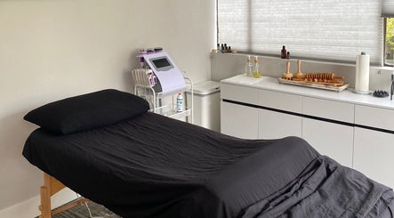 Cozy massage room at Divine Contours Studio, Citrus Heights, California, US. Features treatment bed and equipment.