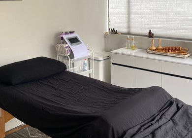 A serene treatment room at Divine Contours Studio, Citrus Heights, California, US with a massage table and essential oils.