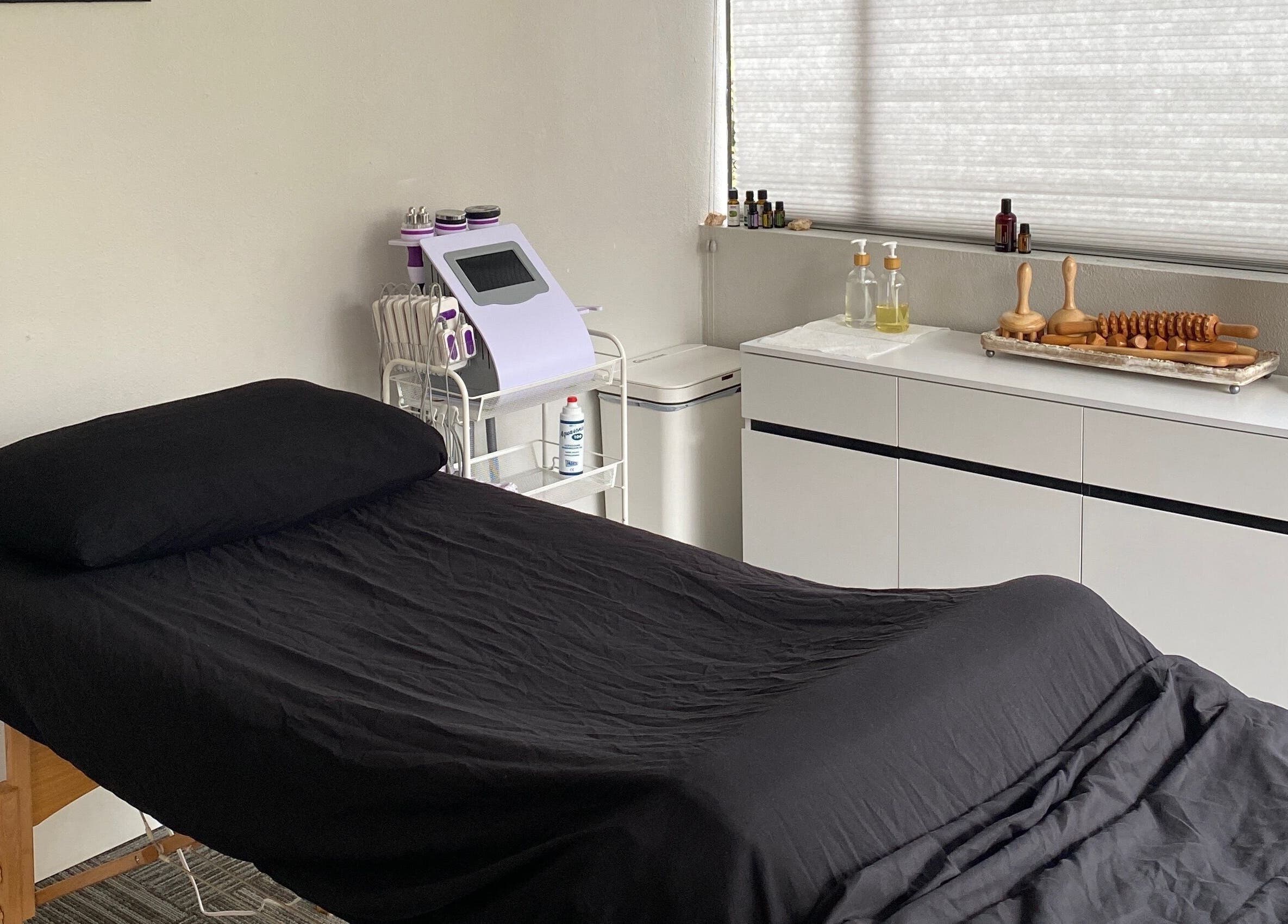 Serene massage room at Divine Contours Studio, Citrus Heights, California, US, featuring a neatly made bed.
