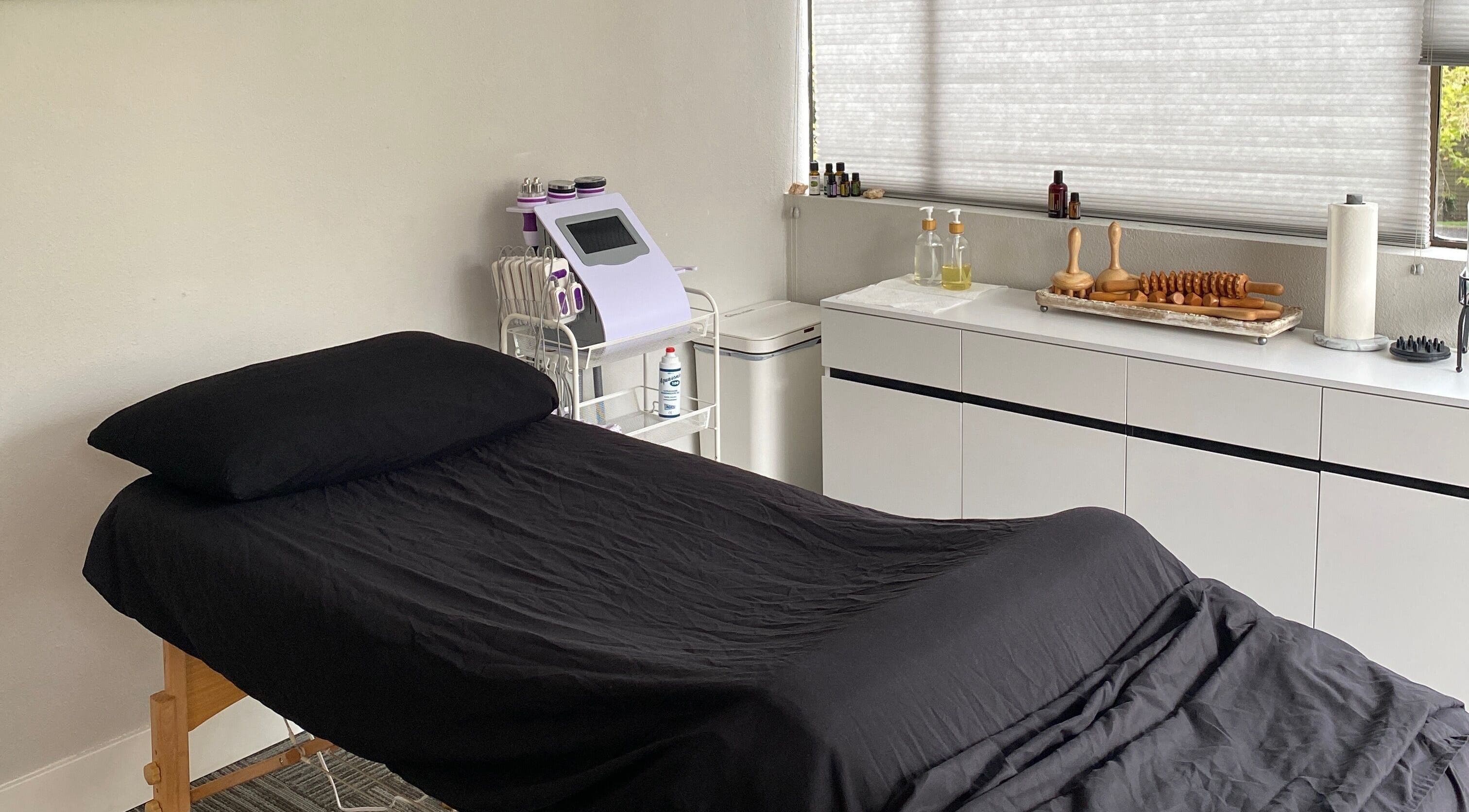 Serene massage room at Divine Contours Studio, Citrus Heights, California, US, featuring a neatly made bed.
