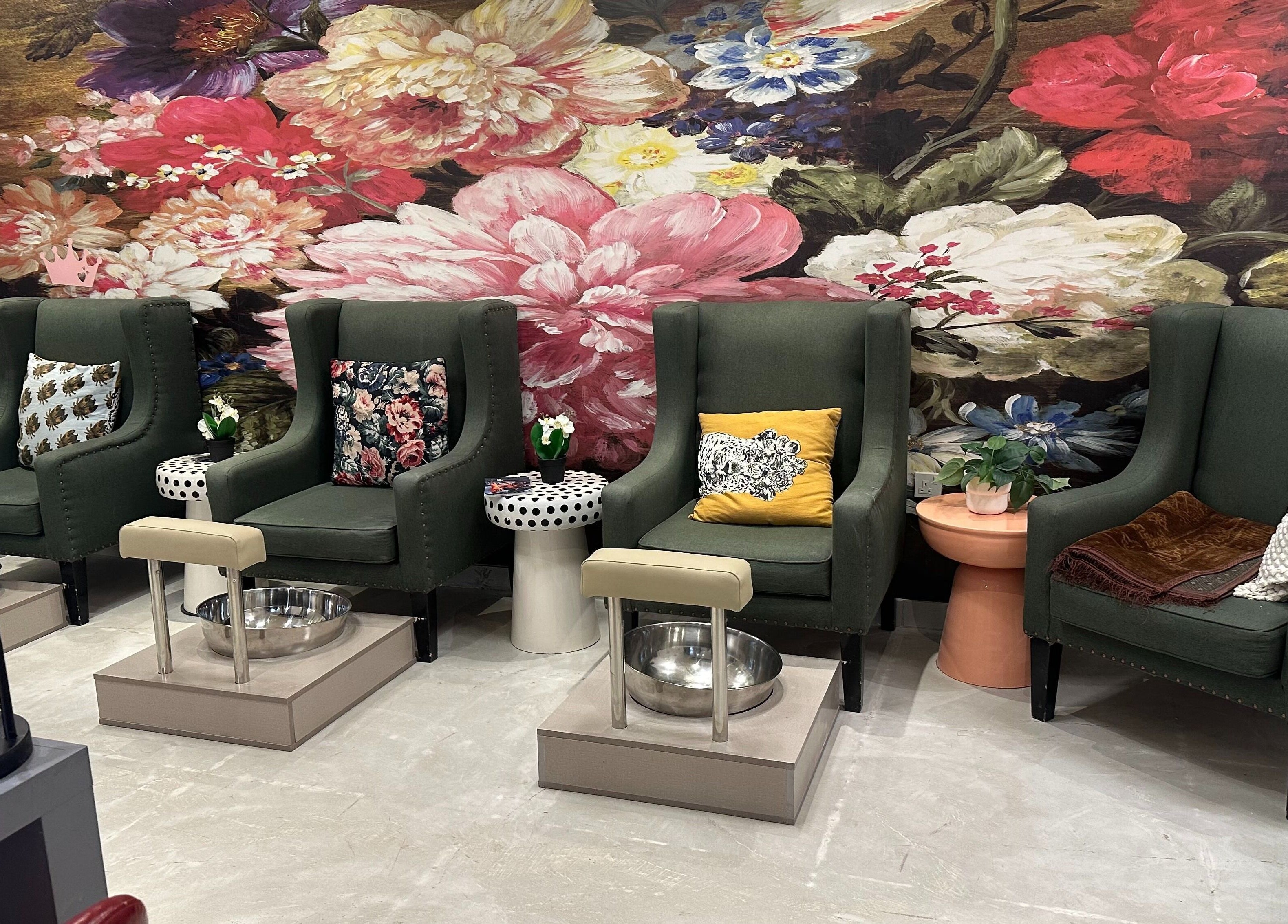 Elegant pedicure chairs at Purple Nail Spa Alyasmin, Riyadh, Riyadh Province, SA. Featuring vibrant floral backdrop.