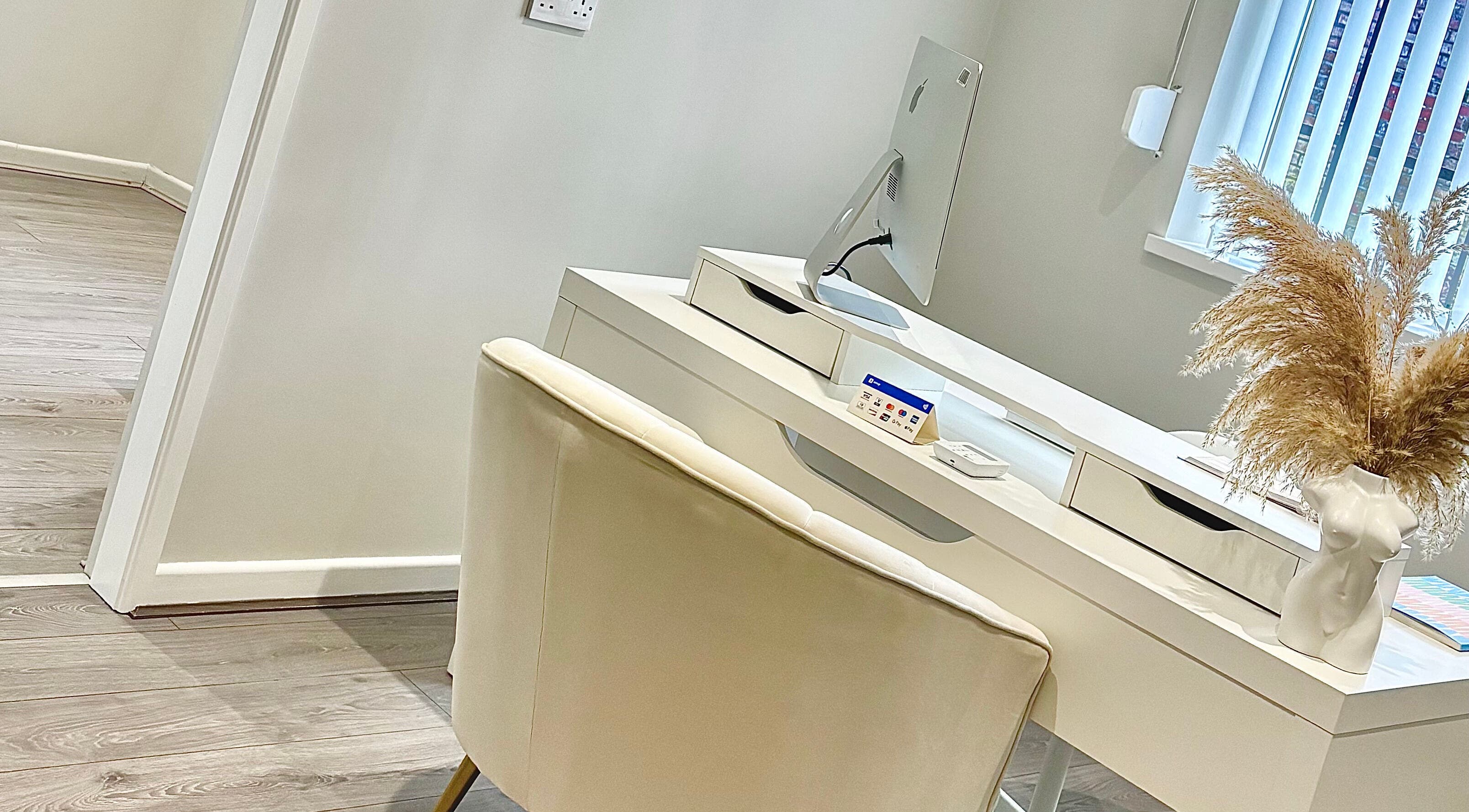 Elegant desk setup at Sculpt Aesthetics, Sunderland, England, GB featuring modern decor and pampas grass.
