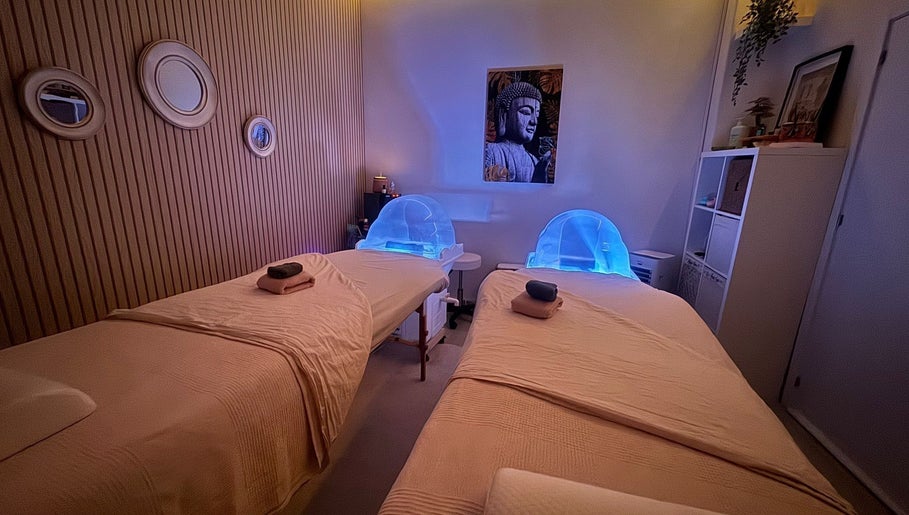 Sala de massagem aconchegante no Ser Amável Spa, Estoril, Lisboa, PT, com camas e iluminação suave.