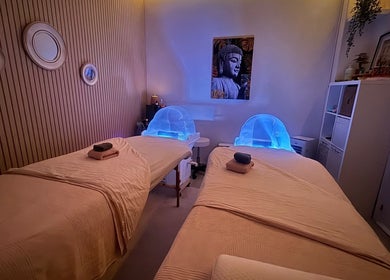 Sala de massagem aconchegante no Ser Amável Spa, Estoril, Lisboa, PT, com camas e iluminação suave.