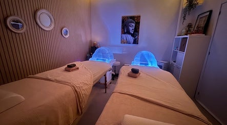 Sala de massagem aconchegante no Ser Amável Spa, Estoril, Lisboa, PT, com camas e iluminação suave.