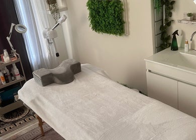 Sala de tratamento de beleza no Ser Amável Spa, Estoril, Lisboa, PT. Toalhas brancas, decoração verde.