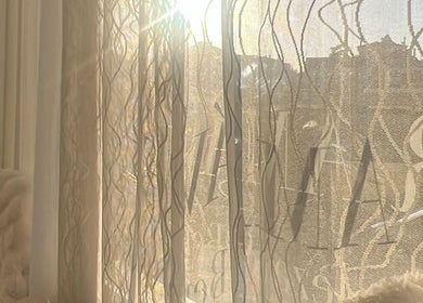 Luz do sol atravessa cortina no Ser Amável Spa, criando ambiente sereno em Estoril, Lisboa, PT.