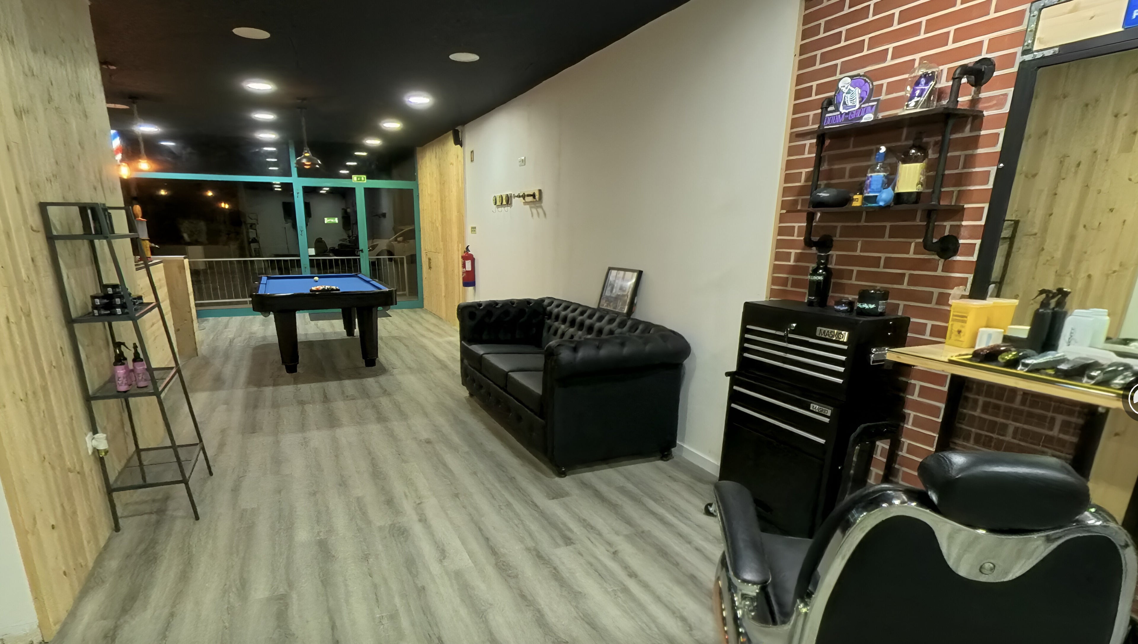 Ambiente acolhedor no Paddock Barbershop ®️, Lixa, Porto, PT, com sofá elegante e mesa de bilhar.