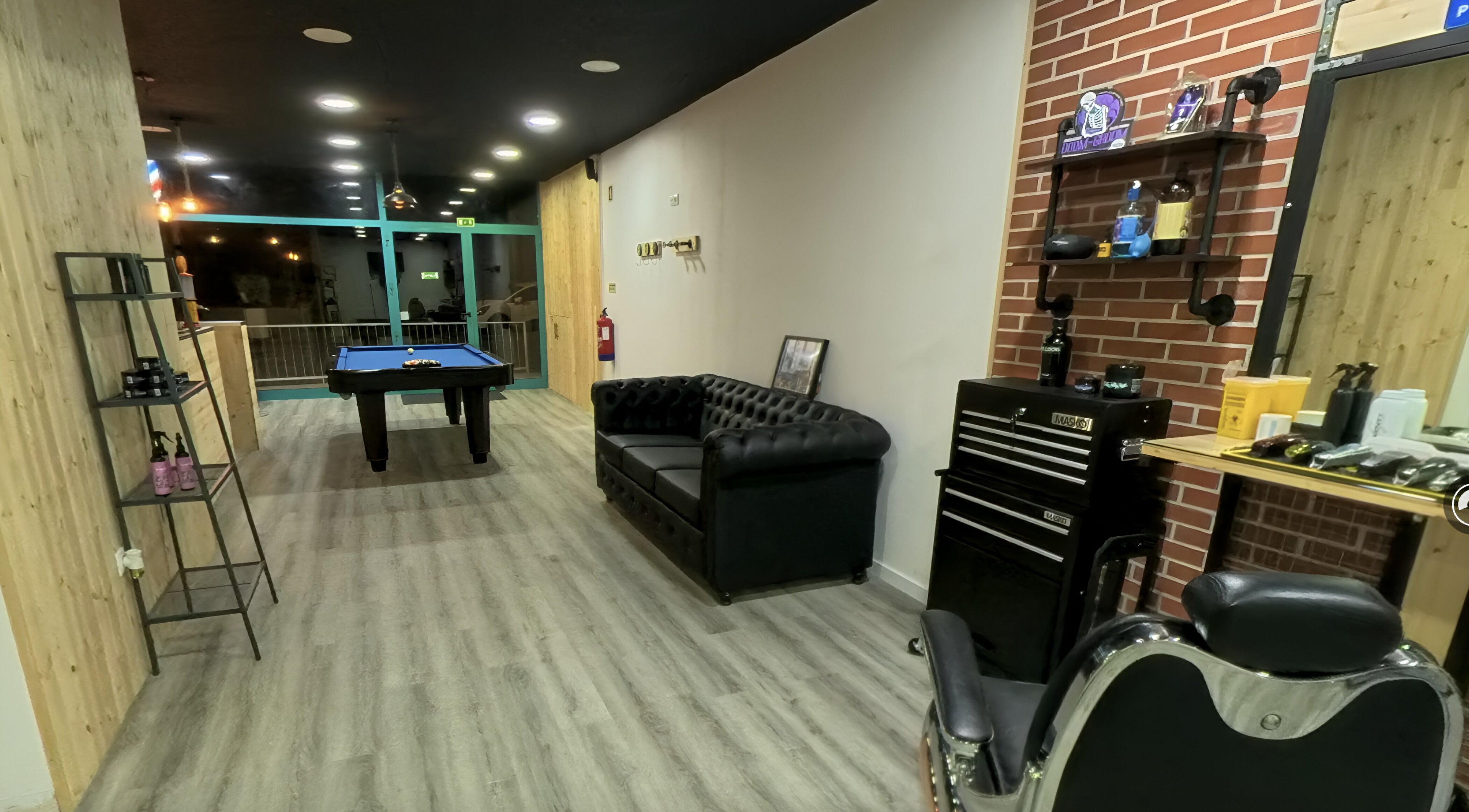 Ambiente acolhedor no Paddock Barbershop ®️, Lixa, Porto, PT, com sofá elegante e mesa de bilhar.