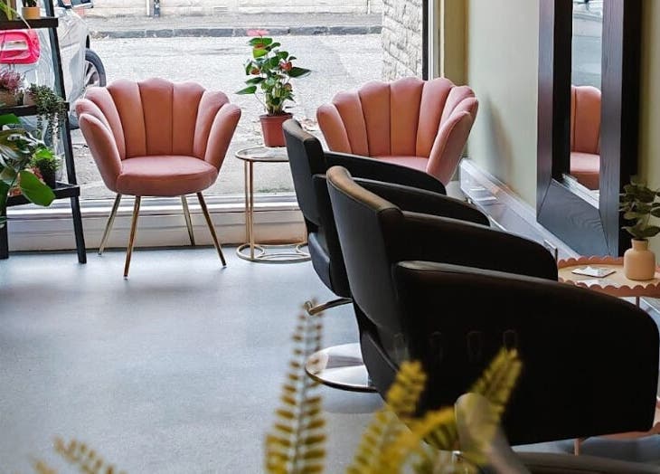 Stylish interior of Eden Hair Studio, Port Seton, Scotland, GB with pink chairs and lush plants.