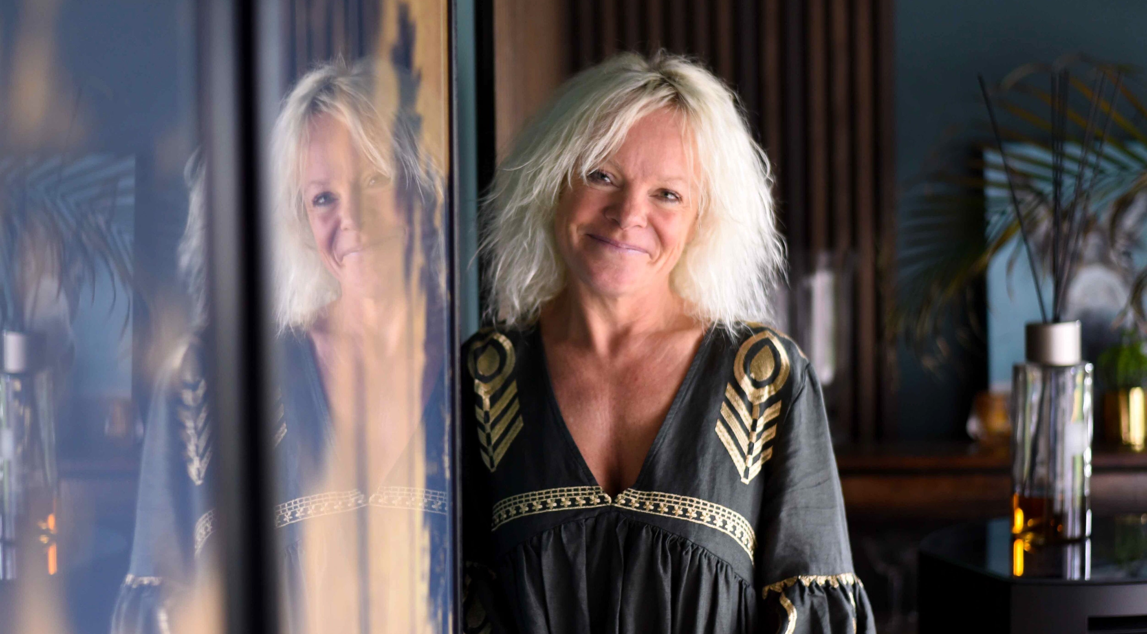 Smiling woman in elegant dress at The Boughton Clinic, Ashford, GB, reflecting ambiance of tranquility.