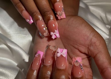 Stylish pink nails with bows at The Nail Vanity, Montego Bay, St. James Parish, JM.