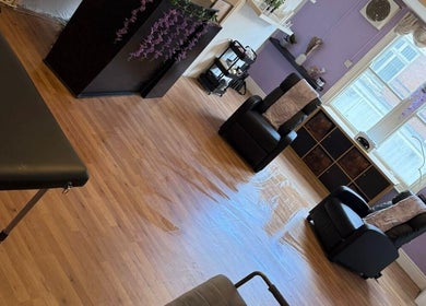 Relaxing spa area at Hair HQ Ilkeston, Ilkeston, England, GB with massage table and chairs in serene setting.