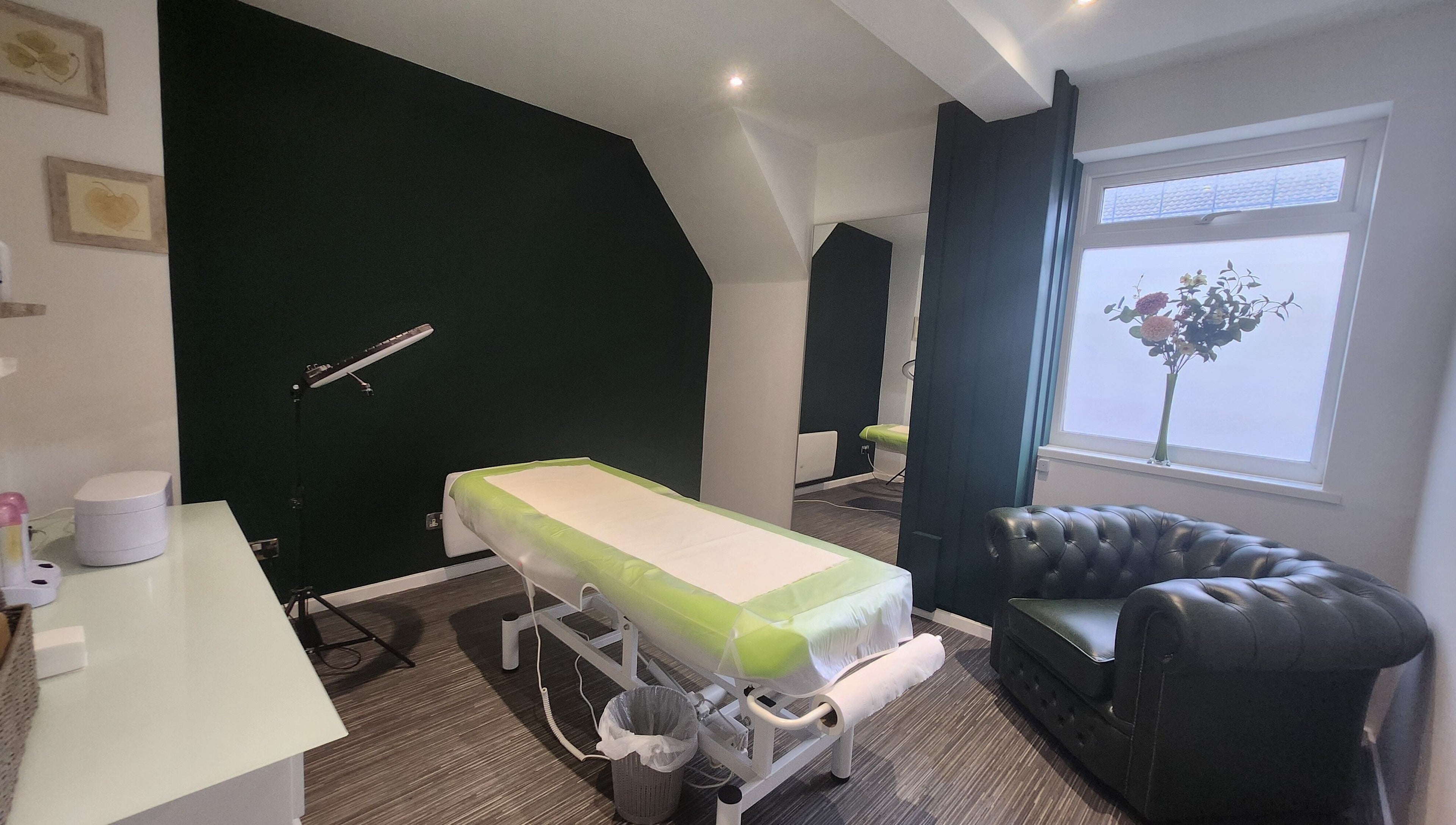 Tranquil treatment room at Next Level spa & beauty, Wallsend, England, GB, featuring a massage table and comfy seating.