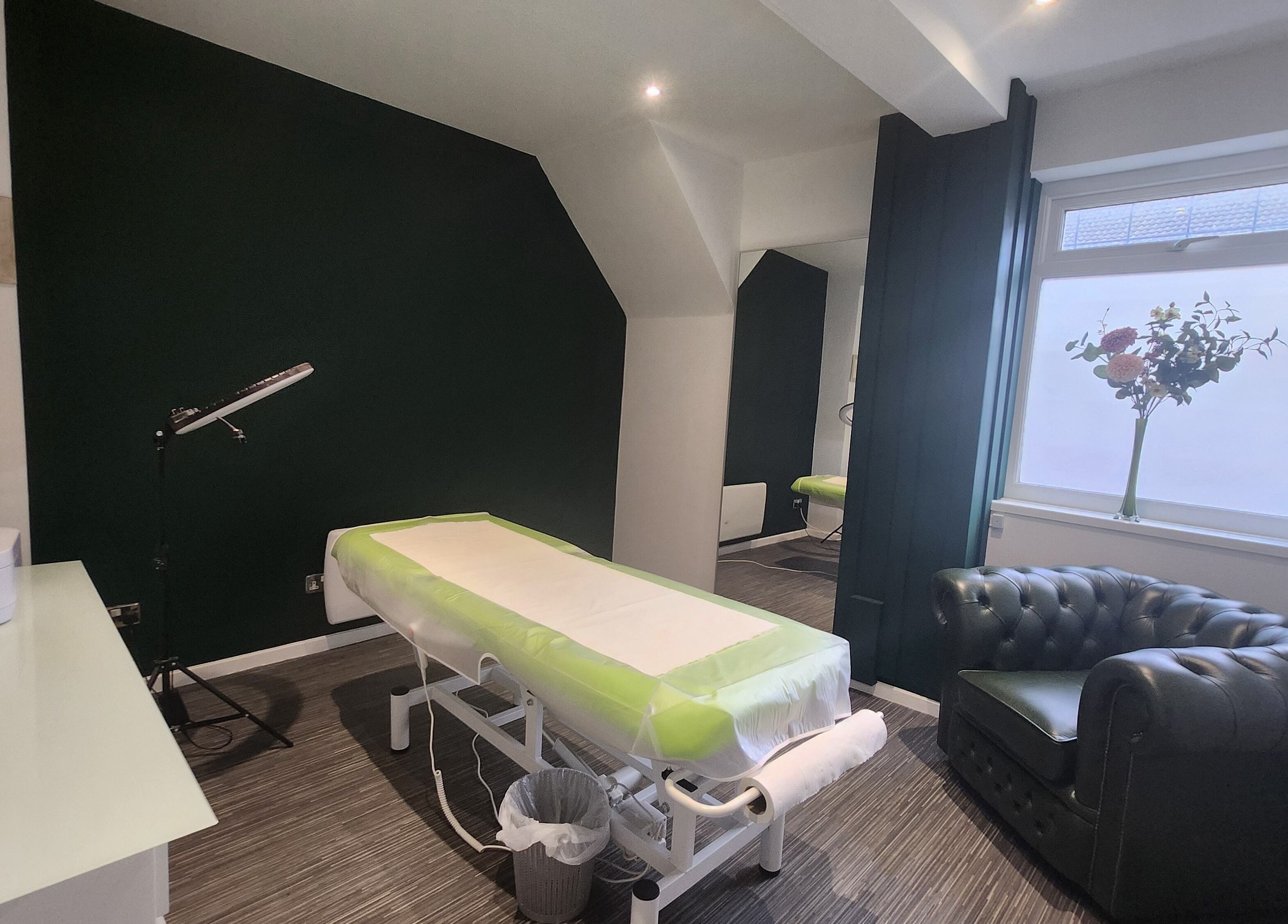 Tranquil treatment room at Next Level spa & beauty, Wallsend, England, GB, featuring a massage table and comfy seating.