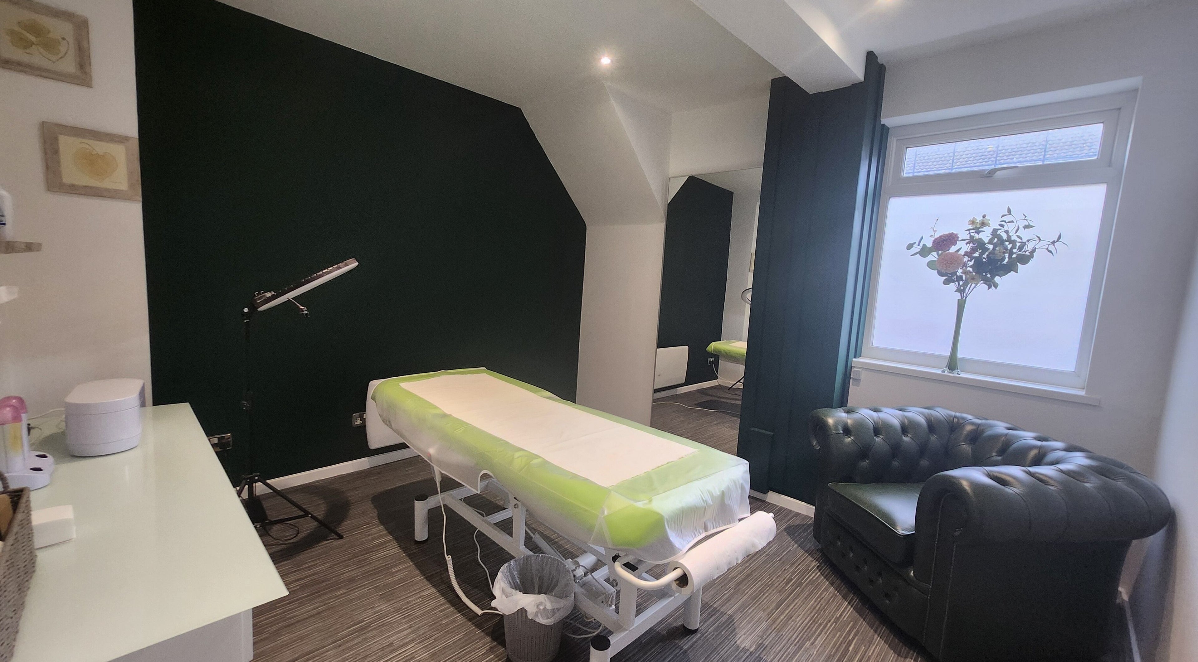 Tranquil treatment room at Next Level spa & beauty, Wallsend, England, GB, featuring a massage table and comfy seating.