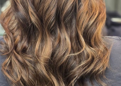 Elegant, wavy hairstyle at Kalos Hair Design, Asheville, North Carolina, US. Perfect for showcasing vibrant highlights.