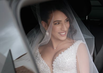 Smiling bride in car at By Paras, Carindale, Queensland, AU with veil and pearl details.