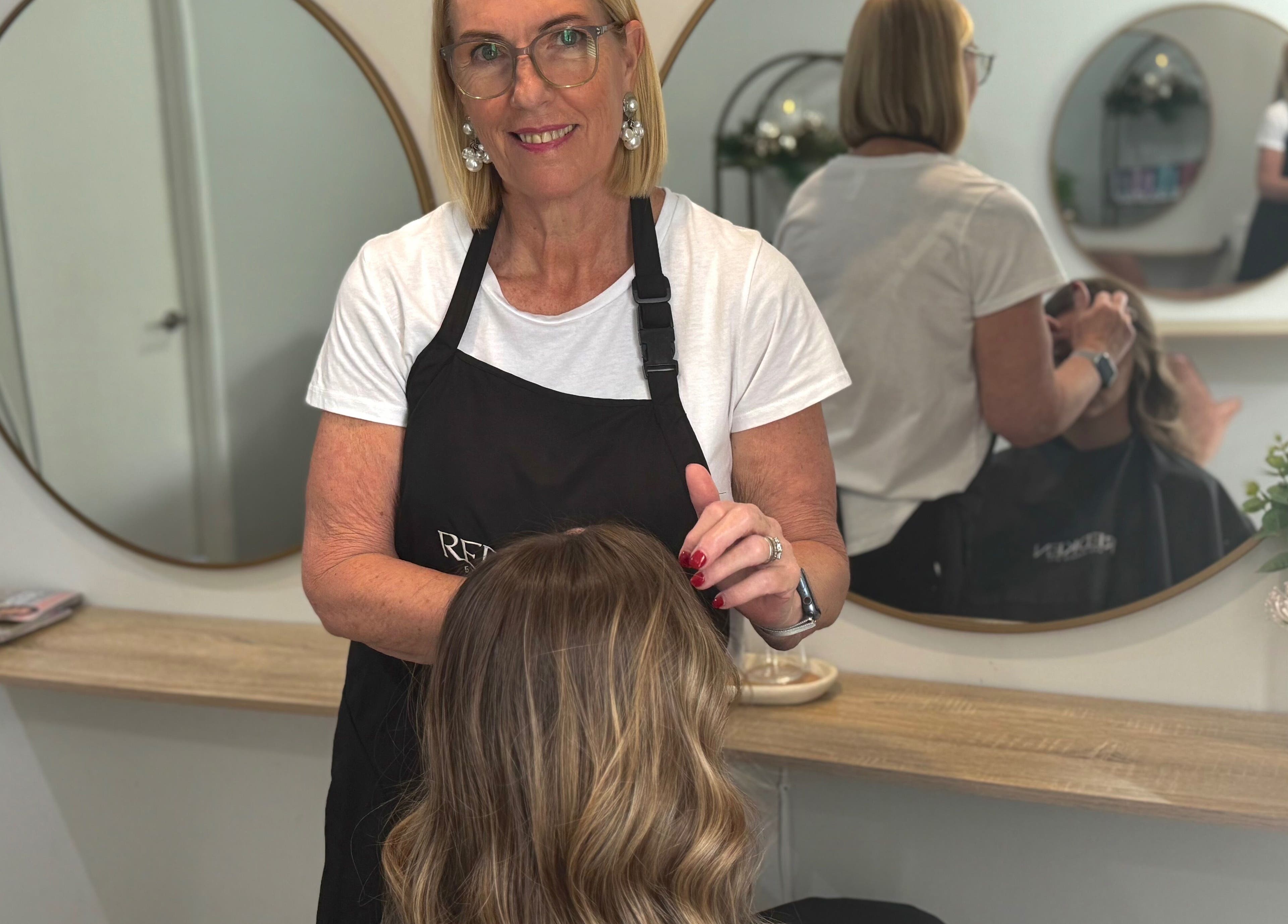 Stylist at Studio 12 - Hair By Fiona in Thornlands, Queensland, AU, skillfully working on a client's hair.