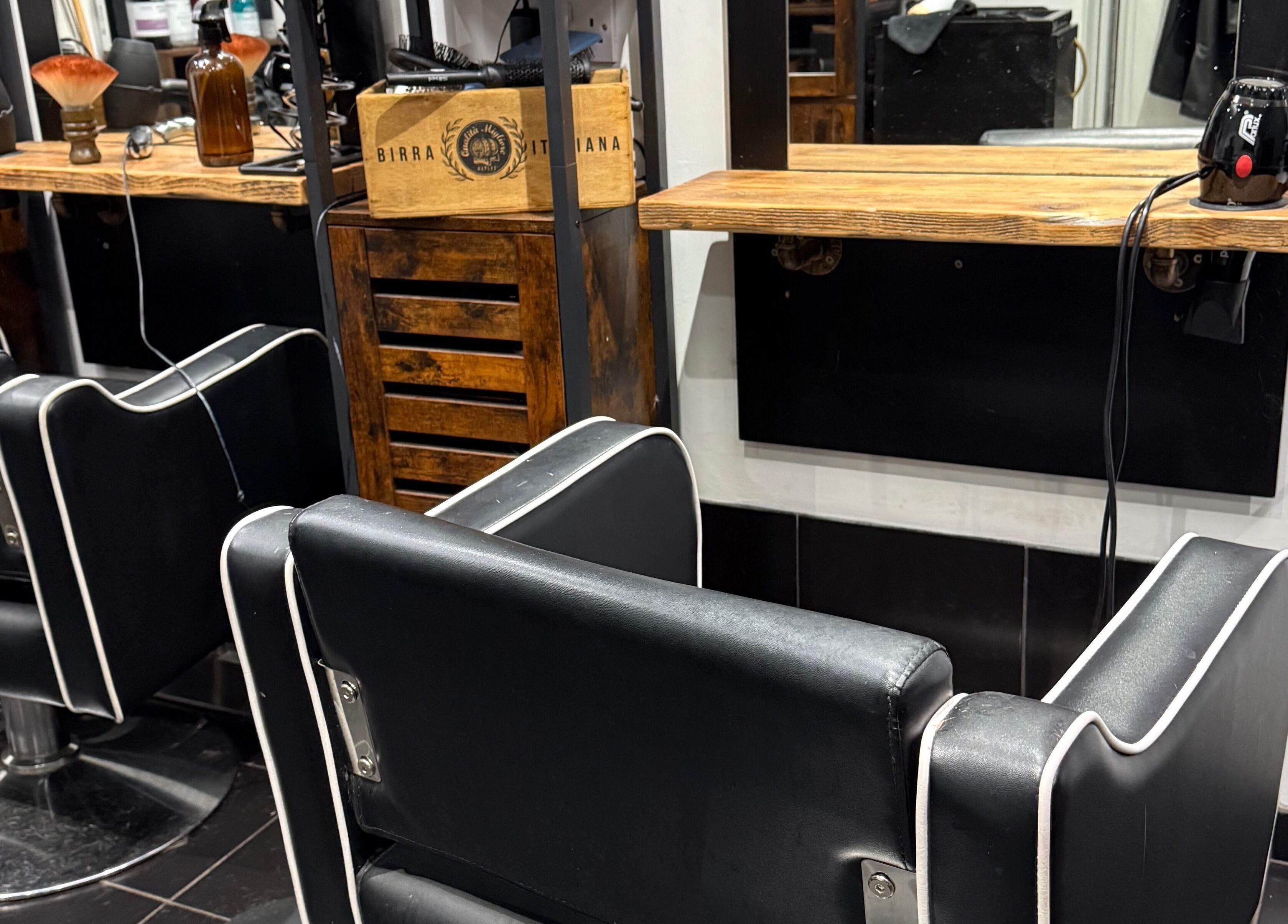 Elegant styling station at The Mane Room, Cookham, England, GB with modern black salon chairs.