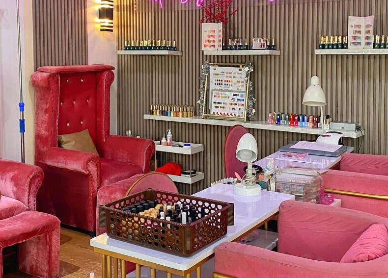 Luxurious seating area at Daily Lounge Salon, Makati, Metro Manila, PH featuring plush pink chairs and nail polish display.