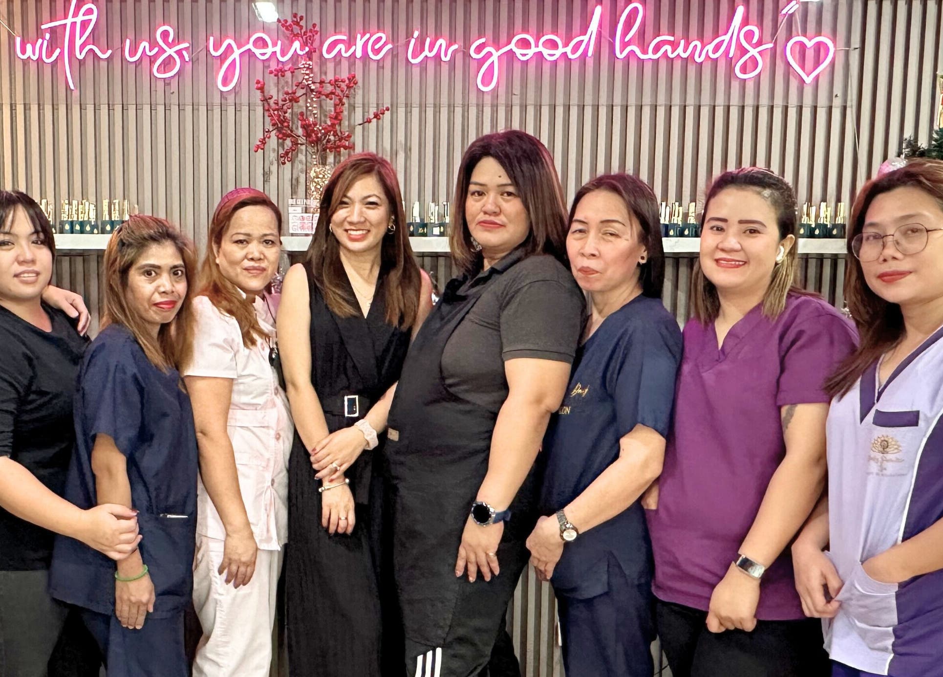 Friendly team at Daily Lounge Salon, Makati, Metro Manila, PH under a welcoming neon sign.