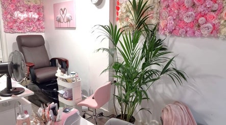 Naiyah Nails salon in London, England, GB features a stylish nail care setup with pink floral decor and comfy seating.