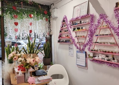Naiyah Nails, London, England, GB showcases elegant nail polish displays with floral decor for a cozy beauty ambiance.