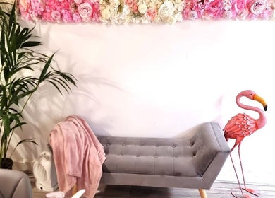 Stylish lounge at Naiyah Nails, London, England, GB with pink flowers, plush seating, and a pink flamingo.