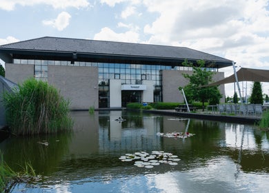 Serene pond view at Digital Arts & Entertainment, Kortrijk, Vlaams Gewest, BE with lush greenery.