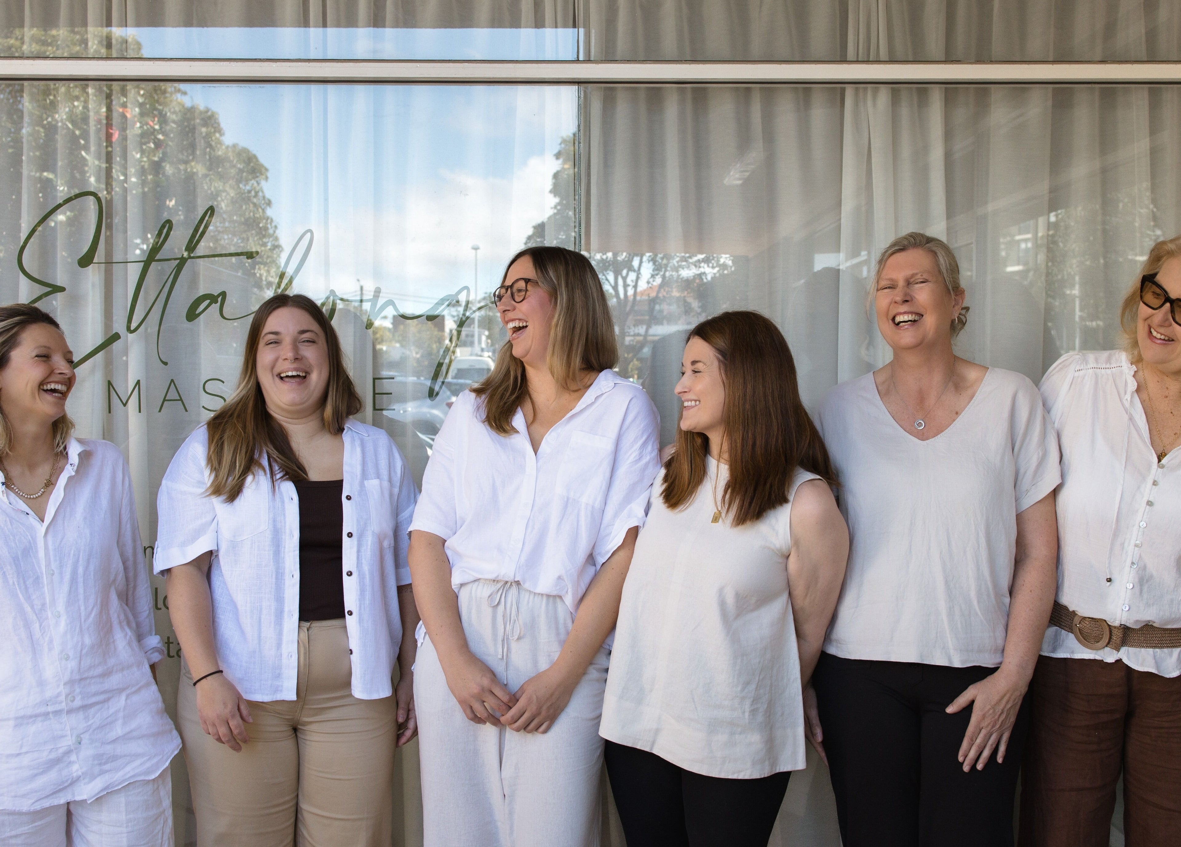 Staff of Ettalong Massage smiling in front of venue at Ettalong Beach, New South Wales, AU.