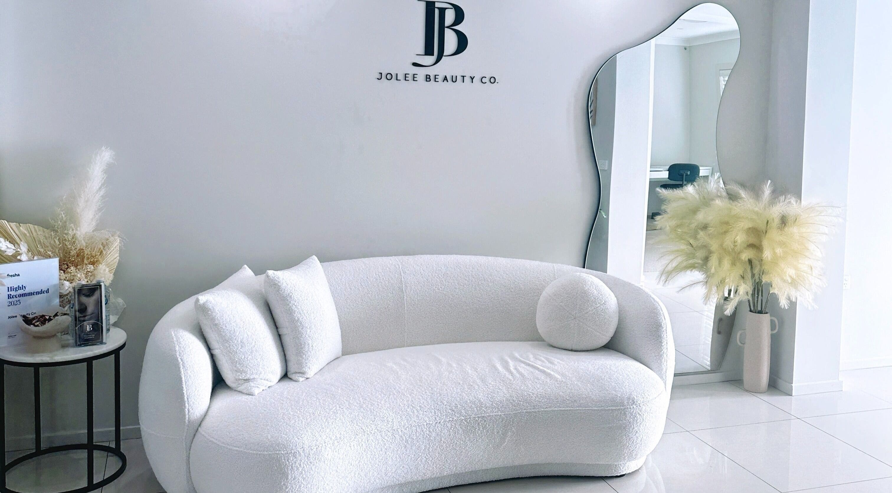 Luxury lounge area at Jolee Beauty Co - Prestons, Prestons, New South Wales, AU with stylish decor and mirror.