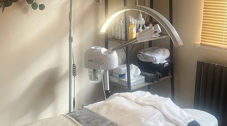 A serene treatment room at Zafirah Aesthetic Studio, London, England, GB, featuring a massage table and skincare products.