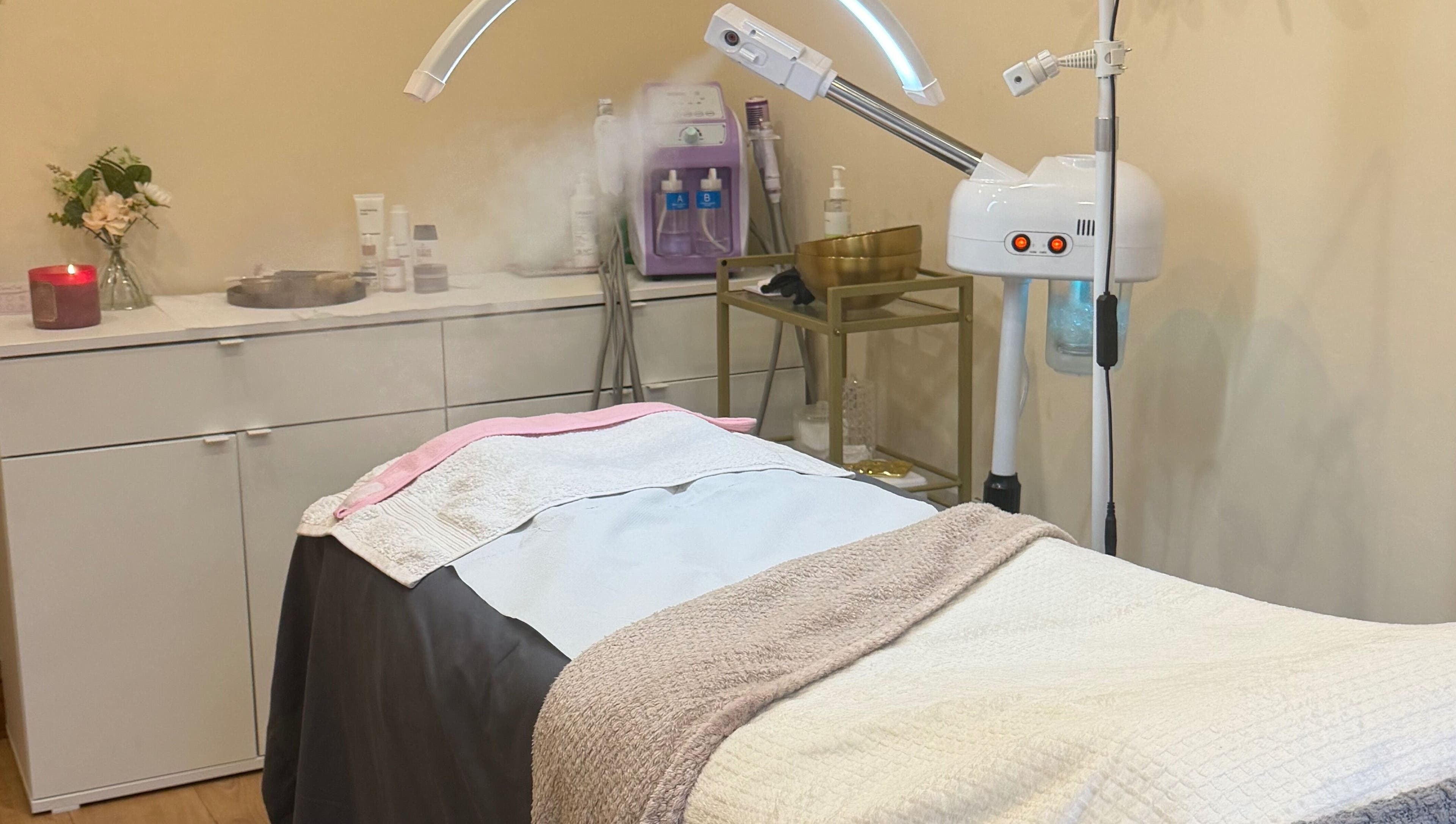 A serene treatment room at Zafirah Aesthetic Beauty, London, England, GB, with a massage table and equipment.